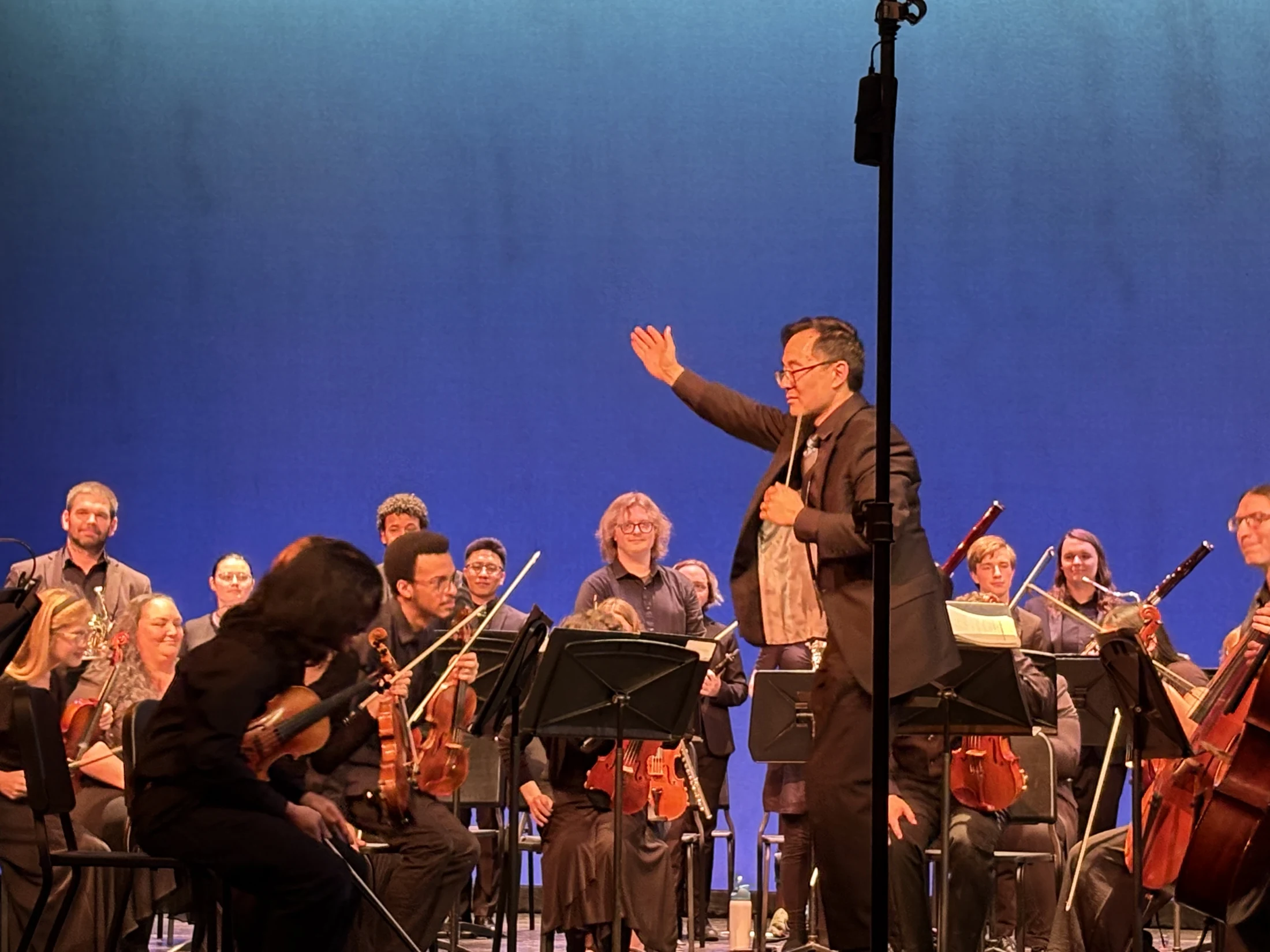 The conductor acknowledging the orchestra on the University Theatre stage
