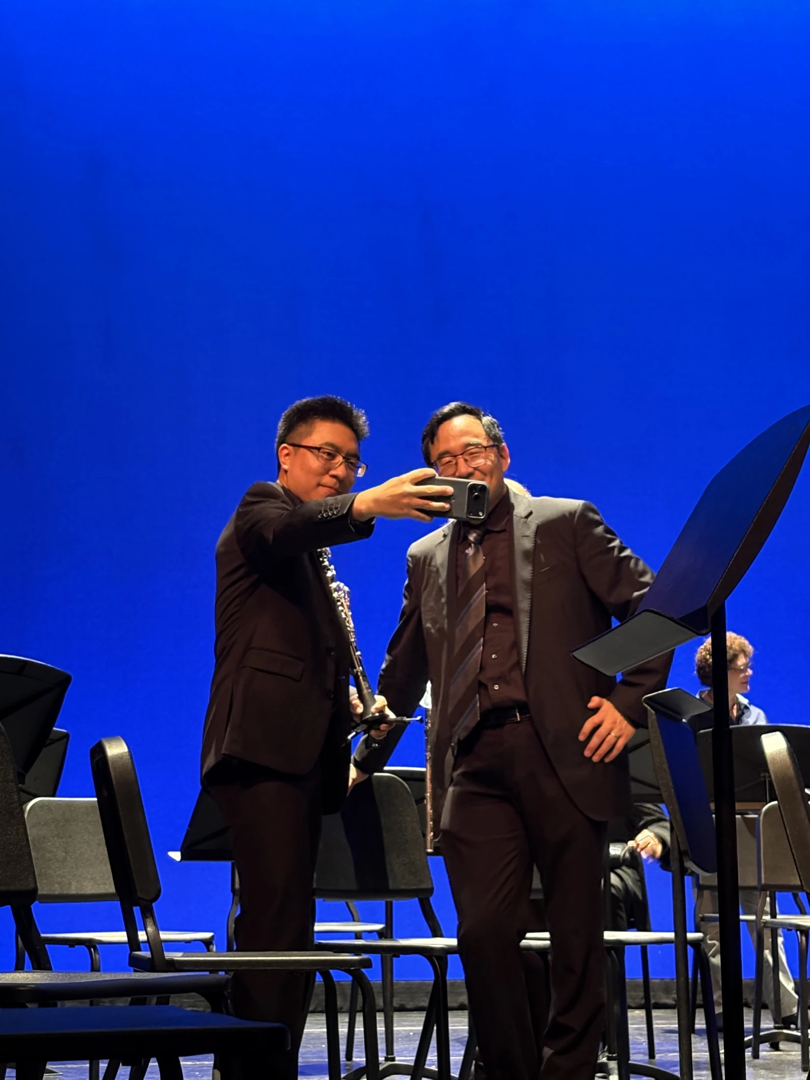 Yi Tang holding his clarinet for a post-concert photo on stage with Director Dr. Kim.