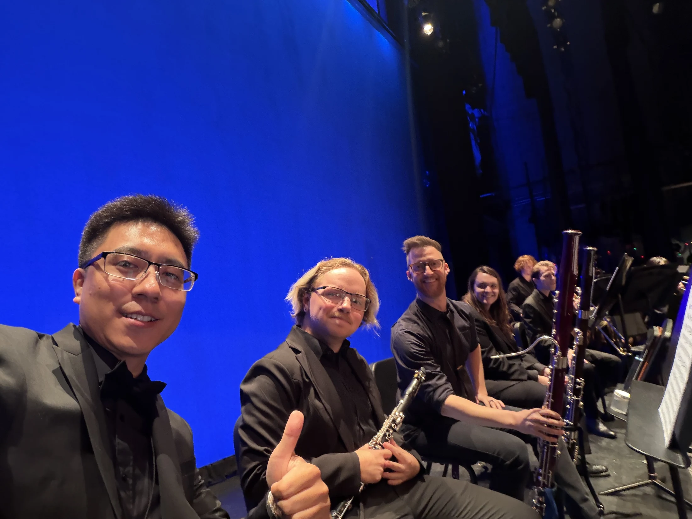 Yi Tang with fellow woodwind players on the University Theatre stage